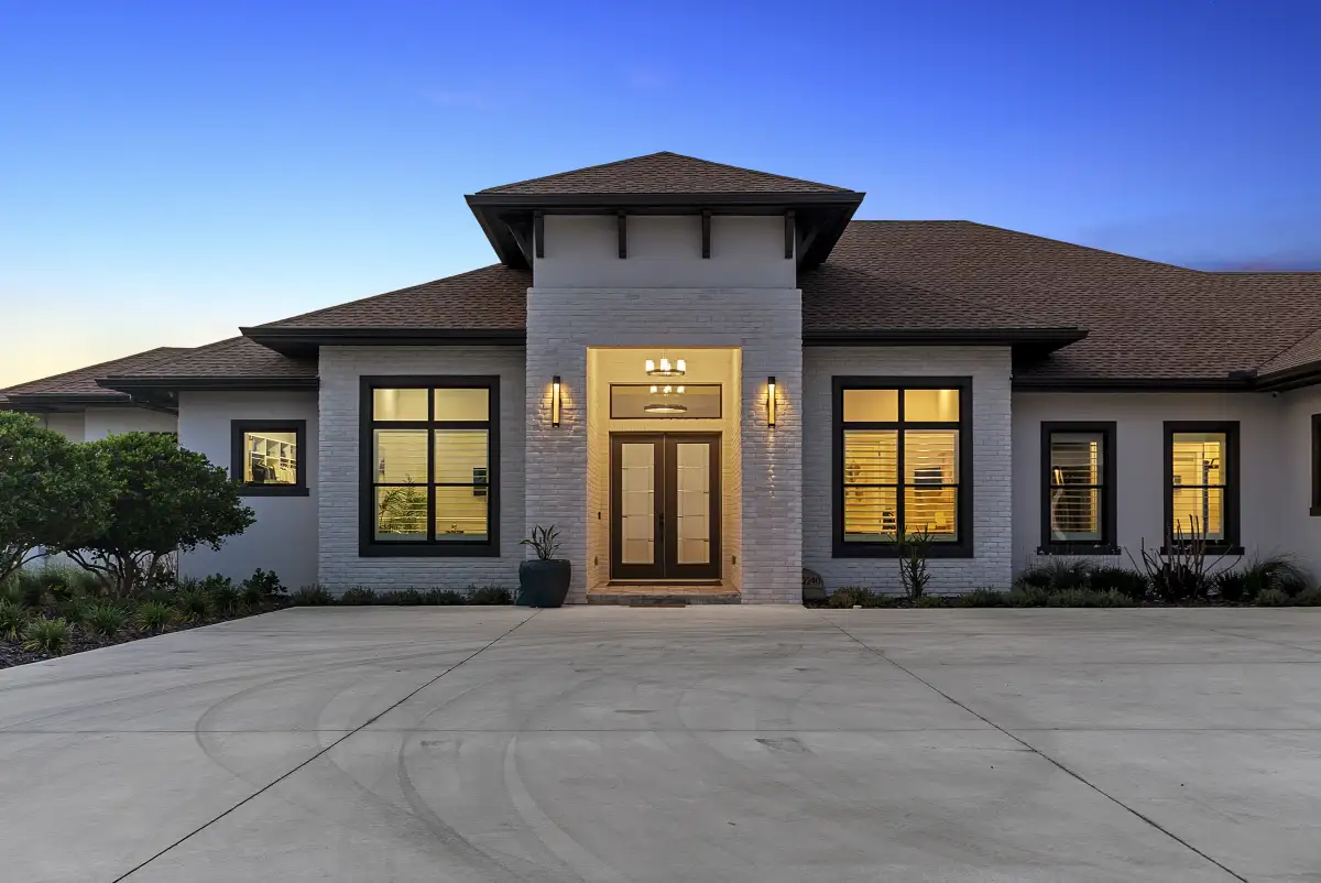 Front entry of the home at dusk with symmetrical glowing windows