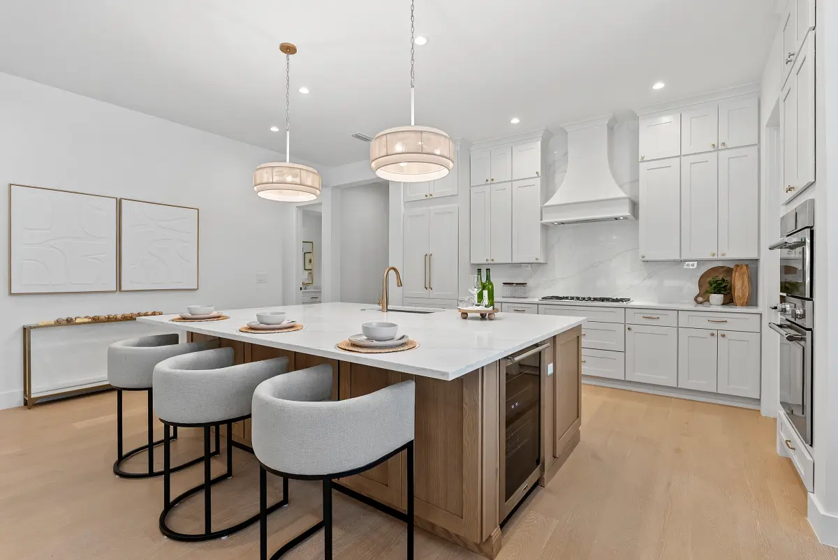 Kitchen with drum pendants, grey bar stools, and a pair of white art panels
