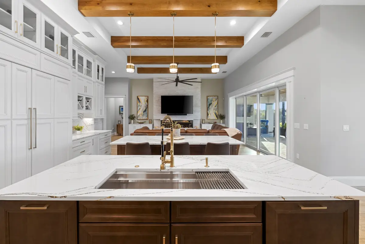 Kitchen island with a wood-beam ceiling and the great room beyond